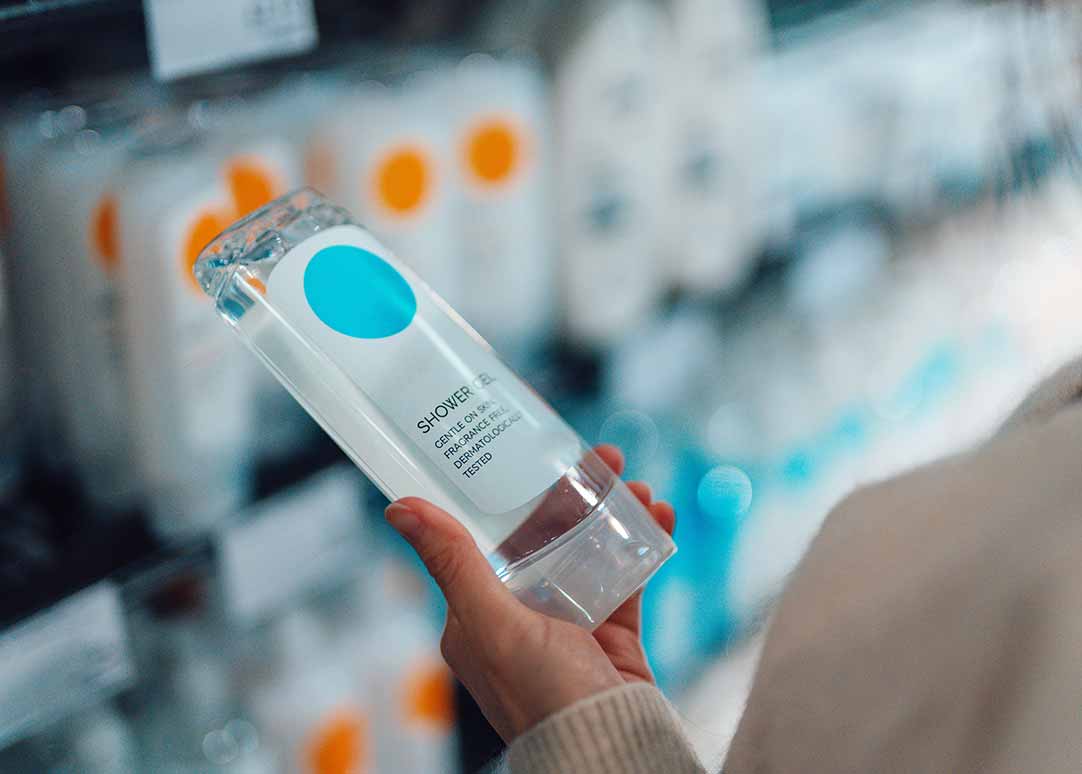 woman holding shower gel bottle