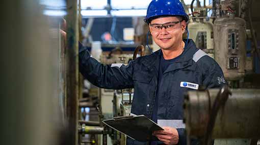 Man smiling with safety helmet and glasses win Vibrantz workwear
